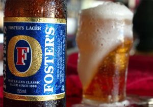a-bottle-of-fosters-beer-stands-near-a-freshly-poured-glass-